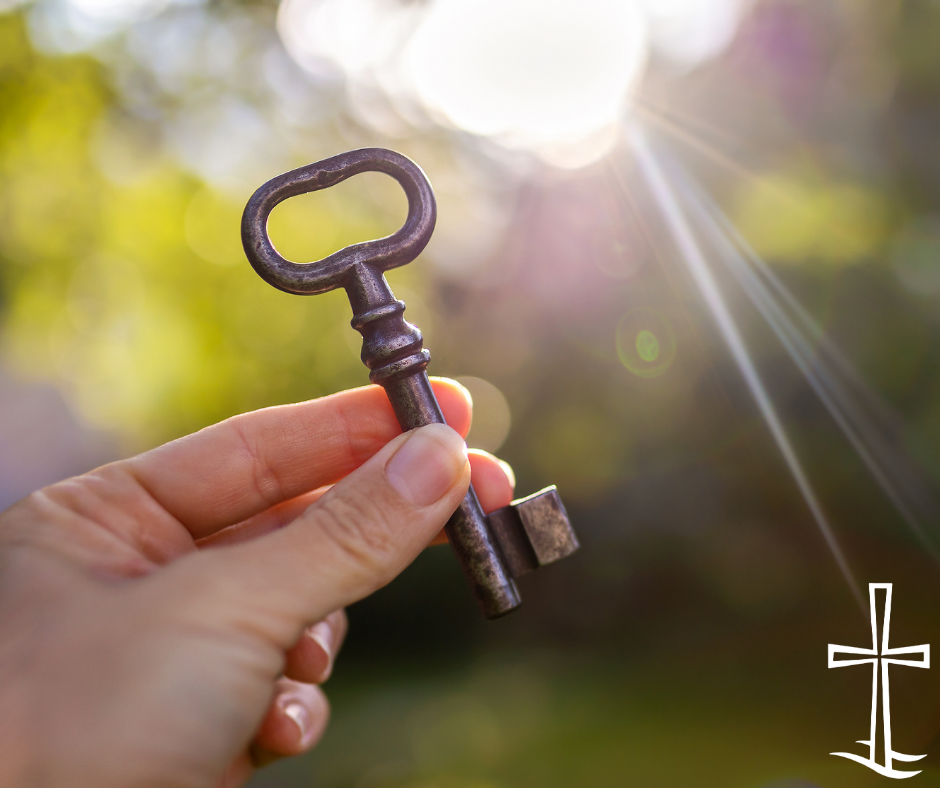 a hand holding a skeleton key in a ray of sunshine